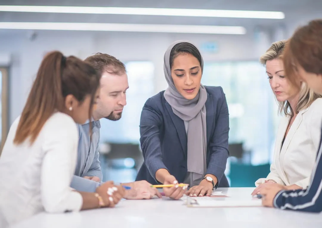 A team working through paperwork together around a meeting table