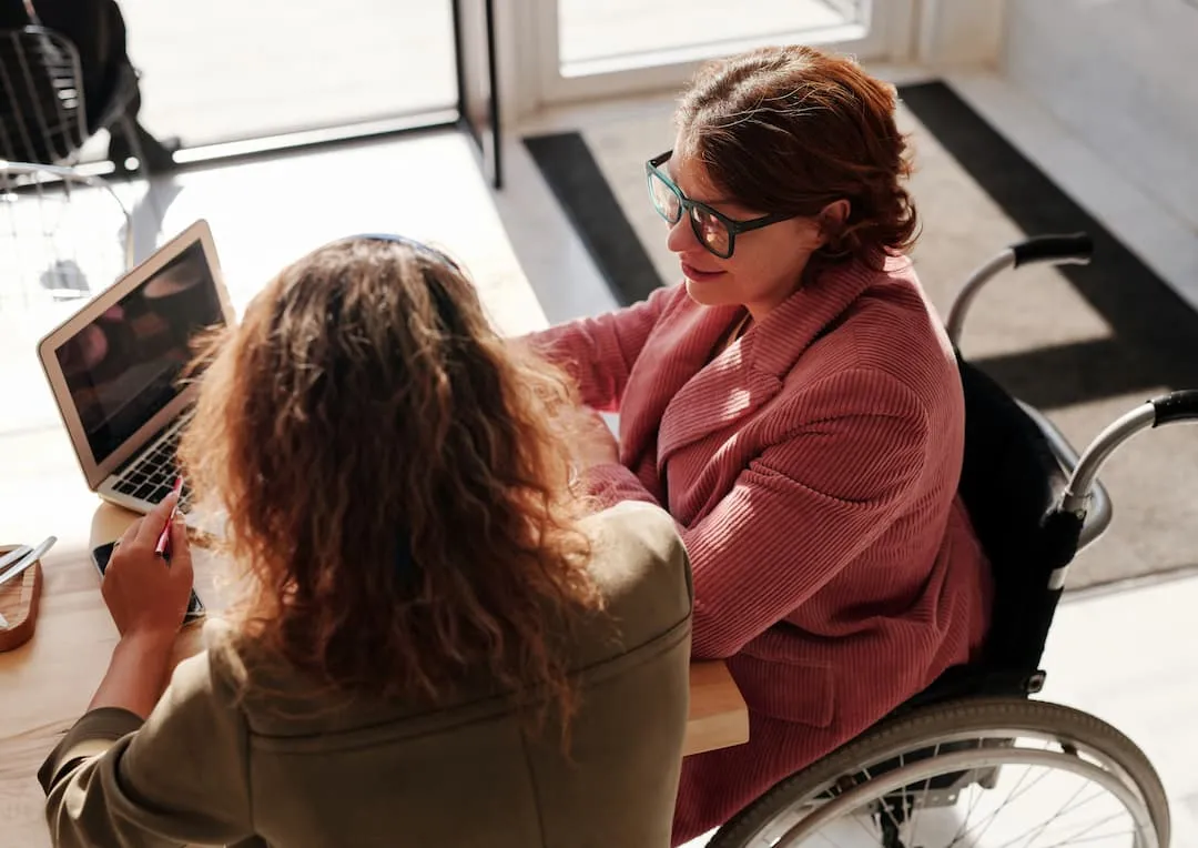 Two colleagues going over a plan on a laptop together